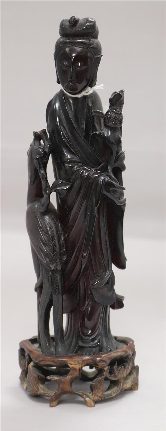 A Chinese faux amber standing figure of Xi Wangmu with a phoenix, wood stand, 23.5cm